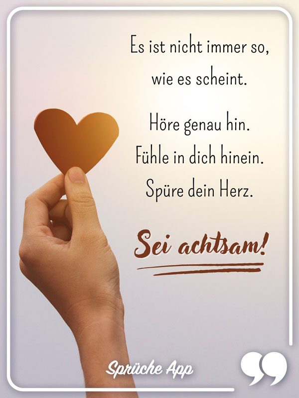 Hand, die ein Herz hält mit Spruch: „Es ist nicht immer so, wie es scheint. Höre genau hin. Fühle in dich hinein. Spüre dein Herz. Sei achtsam!"