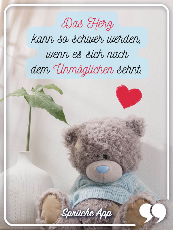 Teddybär mit traurigem Blick und Spruch: „Das Herz kann so schwer werden, wenn es sich nach dem Unmöglichen sehnt."
