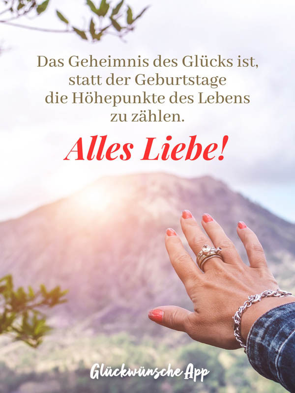 Frauenhand, die sich zur Sonne streckt mit Geburtstagswünsche für Frauen: „Das Geheimnis des Glücks ist, statt der Geburtstage die Höhepunkte des Lebens zu zählen. Alles Liebe!"